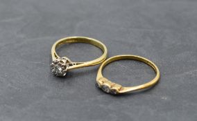 A diamond solitaire dress ring, approx 0.128ct and a three stone diamond trilogy ring, both on