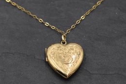 A 9ct gold heart shaped locket having engraved scroll decoration to front on yellow metal chain