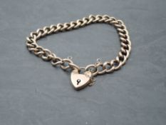 A rose gold curb chain bracelet stamped 9C having padlock clasp and engraved decoration, approx 12.