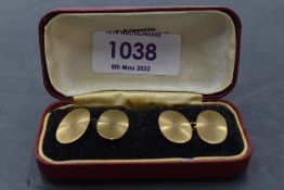 A pair of 9ct gold cufflinks having starburst oval panels with chain connectors, approx 4.7g