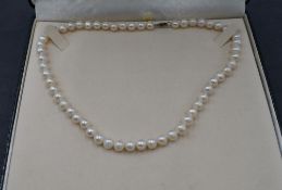 A string of cultured pearls of baroque form having a silver clasp, approx 16'