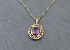 A 9ct gold pendant having an amethyst style stone in a decorative mount on a 9ct gold chain,