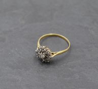 A lady's dress ring having a diamond star burst cluster, approx 0.5ct on a yellow metal loop, no
