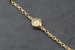A lady's 9ct gold wrist watch having Arabic and baton numeral dial to small circular face in 9ct