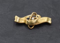 A Swedish 18ct gold brooch of ribbon design having central pearl, date mark for 1920, maker ABH,