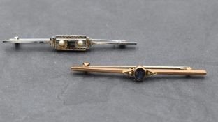 A white metal bar brooch stamped 14ct of Art Deco style having a central sapphire flanked by two
