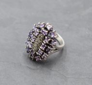 An oversized amethyst and marcasite multi stone ring of artisan form on a white metal loop stamped