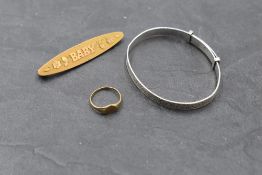Three pieces of baby's jewellery including silver christening bangle, tiny yellow metal heart shaped