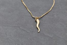 A yellow metal 'horn of plenty' charm on a 9ct gold box chain, approx 18' & 4.4g