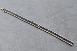 A continental white metal Art Deco style tennis bracelet having a central row of blue paste gems