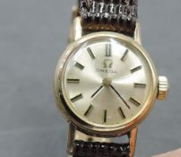 A lady's gold plated Omega wrist watch having baton numeral dial to circular champagne face in