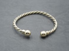 A 9ct gold torque bangle having twist detail and ball knops, approx 30g