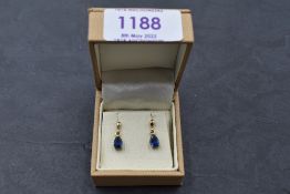 A pair of 9ct gold stud earrings having sapphire pear cut drops in claw mounts, approx 1.6g