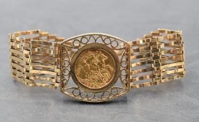 A 9ct gold seven bar gate bracelet with padlock clasp, having central panel holding a 1906 gold