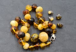 A knotted string of multi coloured Baltic amber beads with two pairs of matched stud earrings, all