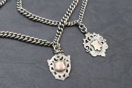 Two HM silver graduated watch chains having dog clip clasps and silver shield medalions with