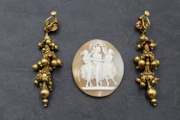 A conche shell cameo plaque depicting the Three Graces and a pair of Indian style yellow metal