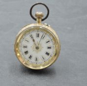 A small yellow metal top wound pocket watch having Roman numeral dial on decorative face in