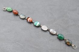 A mixed agate bracelet having nine agate cabochon stones in white metal mounts with chain