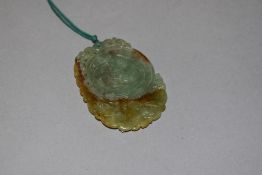 A Chinese style jade or nephrite pendant having carved carp imagery