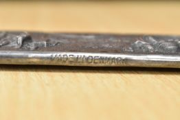 A 20th century white metal comb sheath decorated with musical scenes bearing a Danish mark