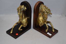 A pair of modern mirrored book ends in the form of Marley or similar horses