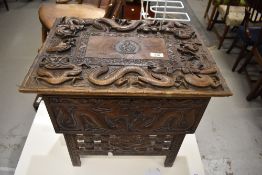 An Oriental box on stand, having fold out legs, possibly campaign related, with carved military