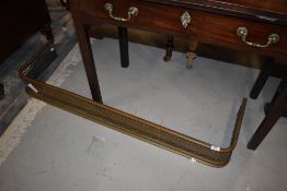 A traditional pierced brass fire fender