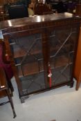 An early 20th Century mahogany display cabinet having astral glazed doors and bracket feet