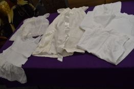 A selection of vintage baby clothes, petticoats and a gown and bonnet.