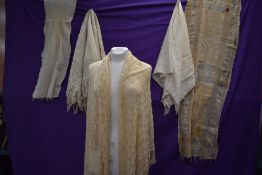 A selection of antique shawls amongst which are two knitted/ crotched examples.