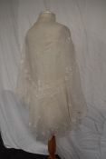 A Victorian lawn cotton shawl having scalloped edging and fine floral embroidery.