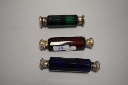 Three Victorian salts or scent bottles with twin compartments in blue, green and red glass