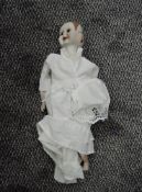 A modern bisque headed doll having three faces with different expressions, bisque limbs and clothed,