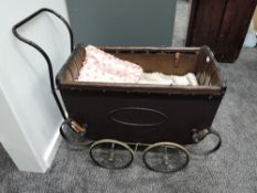A late Victorian/ early 20th century Childs Pram on twin axel metal sprung base, brown leather
