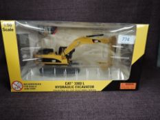 A Norscot 1:50 scale diecast, CAT 330DL Hydraulic Excavator in yellow, in plastic packaging and in
