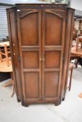 A reproduction priory oak corner wardrobe.