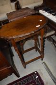 An early 20th Century oak occasional table having twist frame