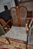 An early 20th Century walnut carver chair having bergere back and stuffed seat