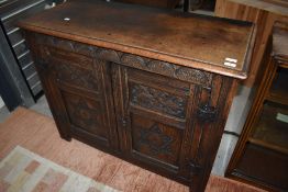 A 19th century oak two door cupboard having carved detailing.