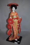 A vintage Japanese Kabuki figure study of a Geisha having porcelain body with glass eyes