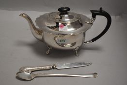 A silver plated tea pot having hard wood handle, frilled rim and paw feet, and three pieces of