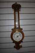 An antique oak case mercury barometer having enamel face marked T & E Rhodes Kendal