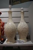 A pair of mid century plaster cast lamp bases with embossed floral design