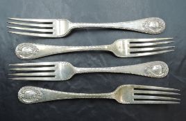 A group of four Edwardian silver table forks, each with fluted edge detail and scrolled cartouche to