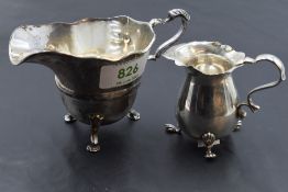 A 1920's silver cream jug of circular form with generous spout and moulded central band, raised on