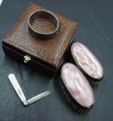 A cased pair of silver rimmed pink clothes brushes, Birmingham 1927, Aaron Lufkin Dennison and a