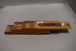 A Beech wood mechanical pen box having various compartments/trays.