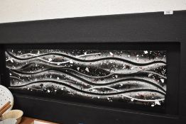 A modernist wall art sculpture in wave form abstract glass design mounted in frame