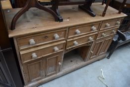 A modern pine dresser base, with central dog kennel section flanked by drawers and cupboards,